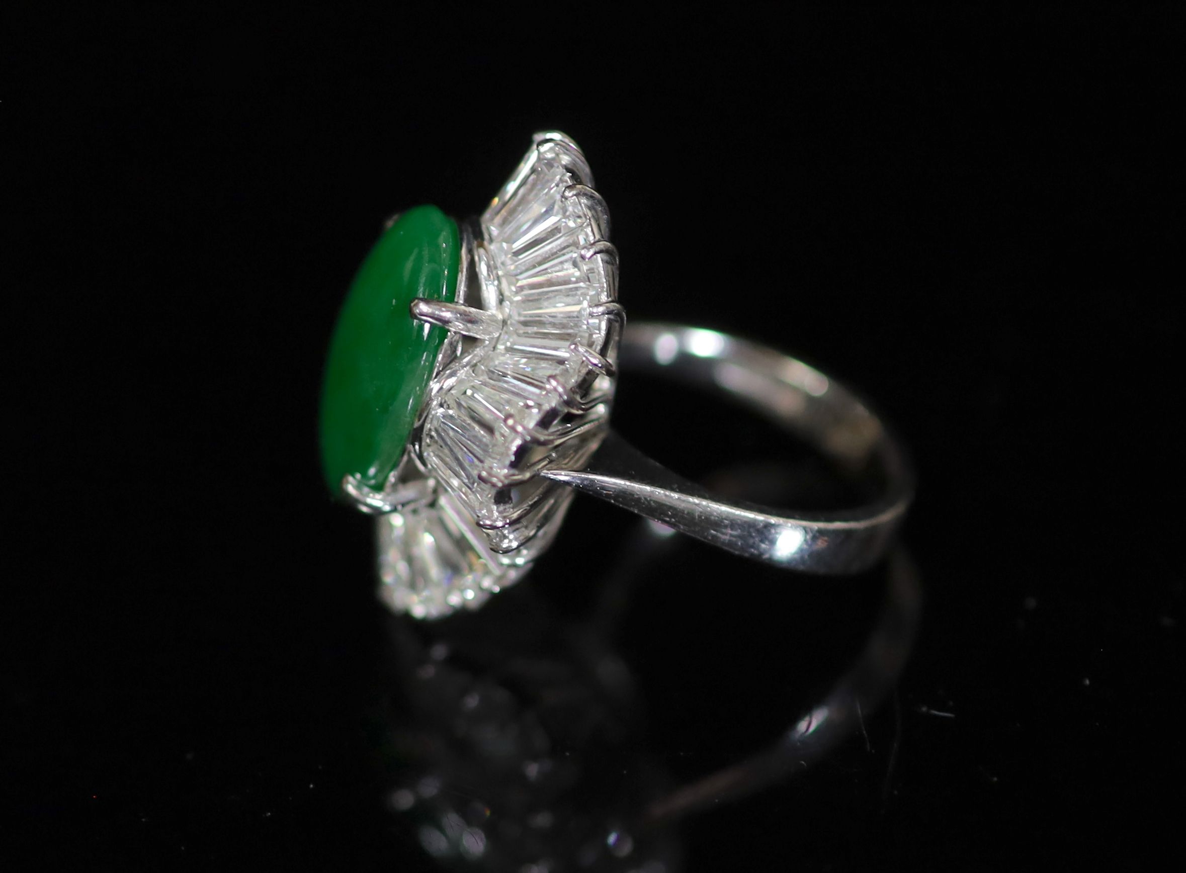 An 18k white gold, green jade and trapeze cut diamond shaped oval 'ballerina' ring, probably Chinese